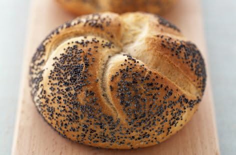 Loaf of bread with poppy seeds on a wooden board