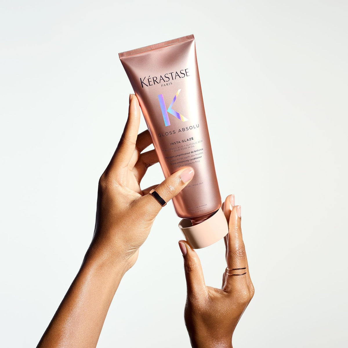 Hand holding a Kerastase product against a light background