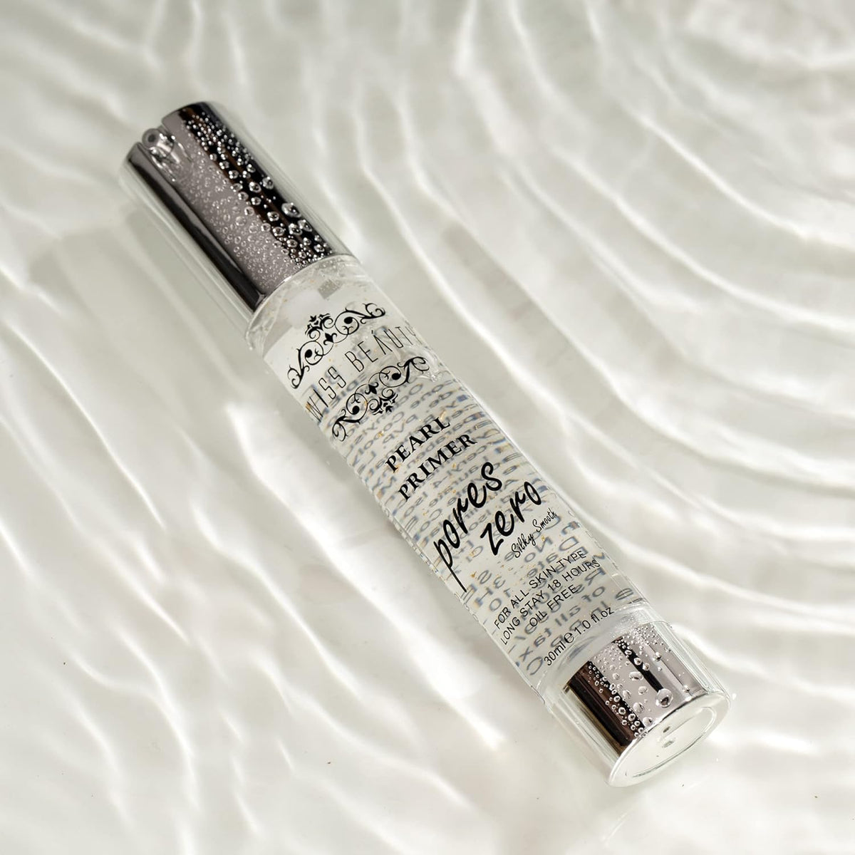 Pearl primer bottle with decorative text on a white fabric background