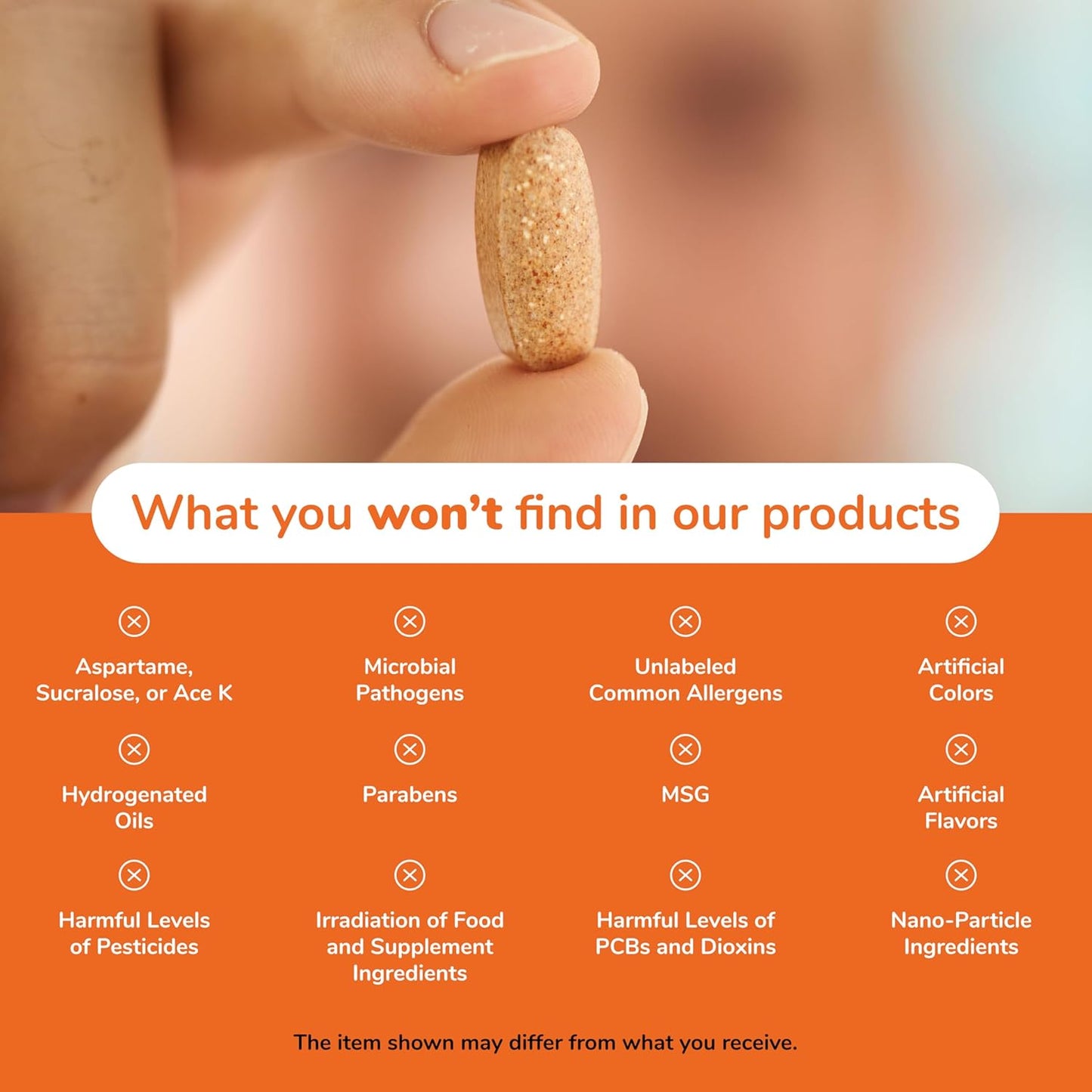 Hand holding a supplement pill with a list of ingredients not found in their products on an orange background.