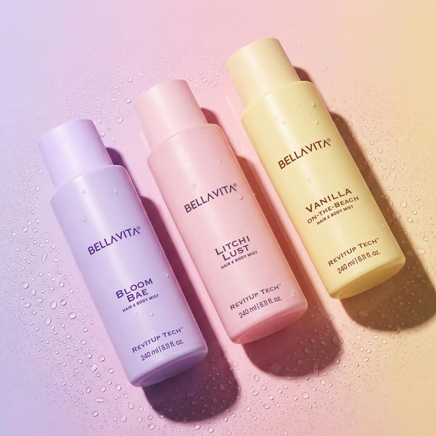 Three BellaVita hair and body mists on a gradient background