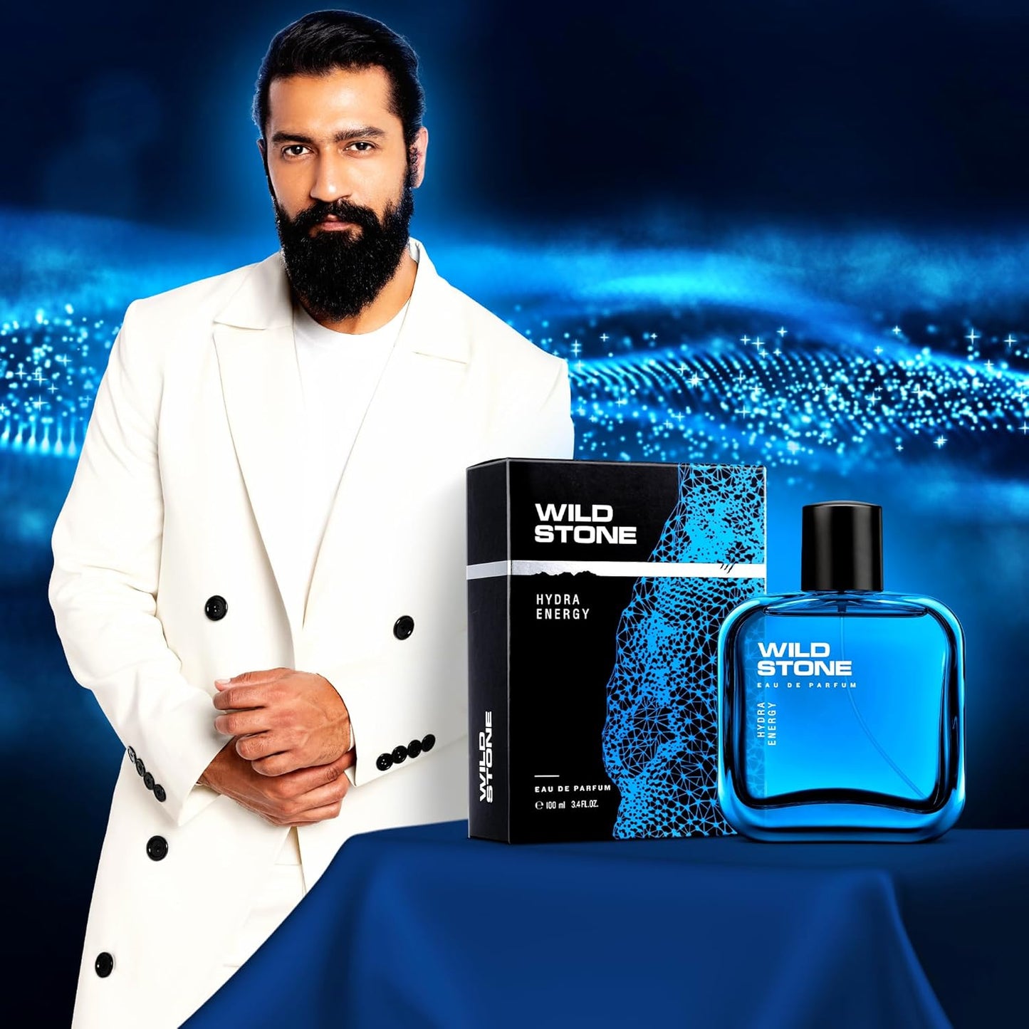 Man holding Wild Stone perfume with product packaging against a blue and black gradient background