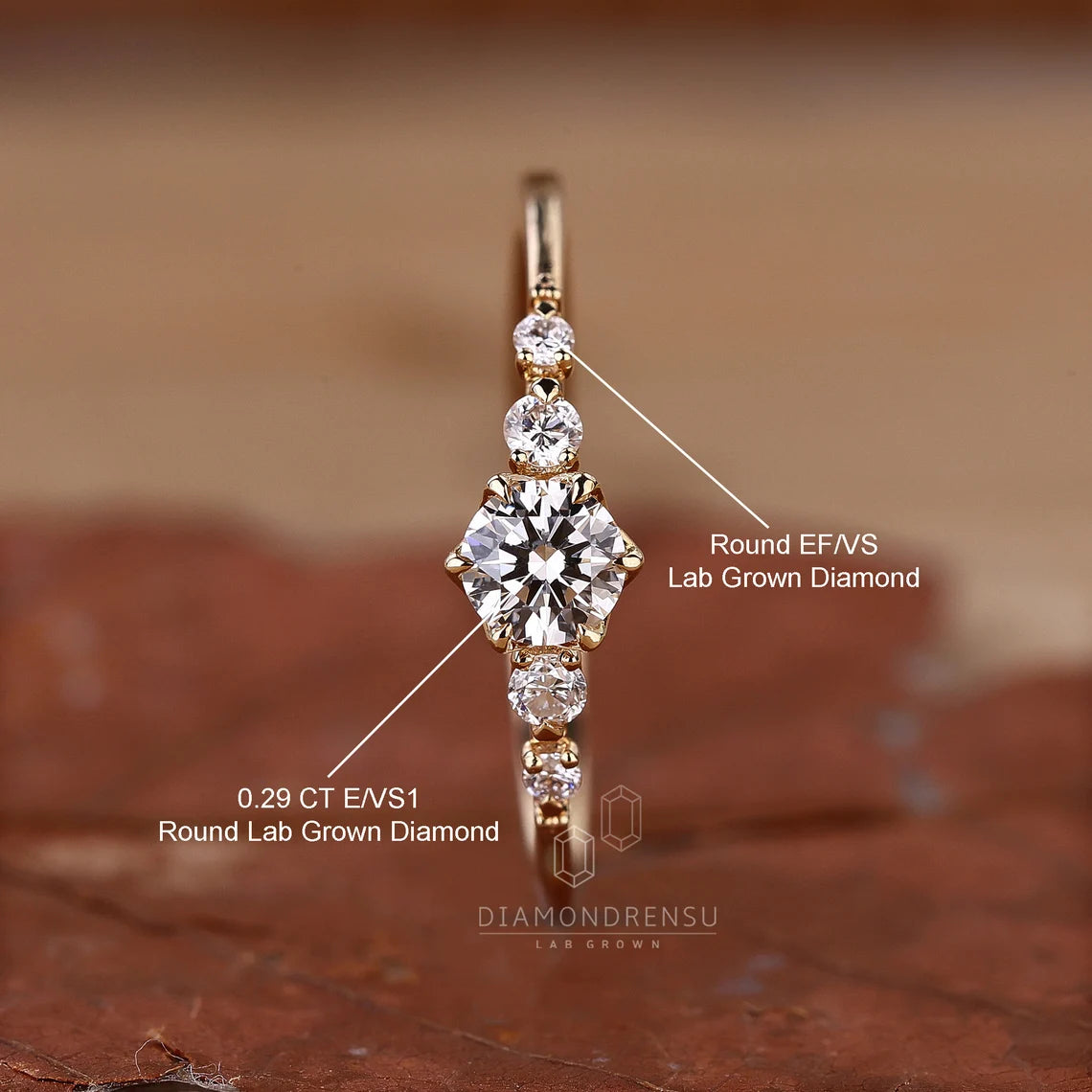 Gold ring with lab-grown diamonds on a brown background