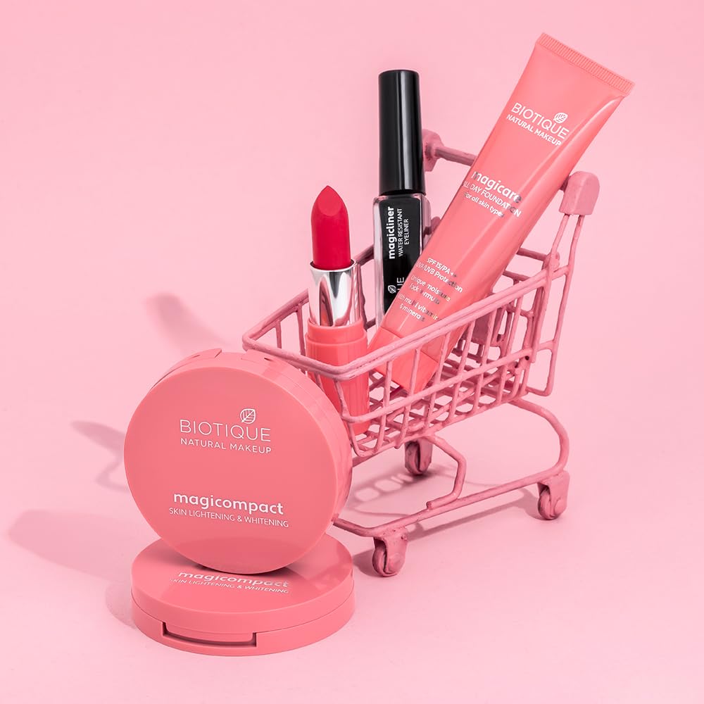Biotique makeup products including a lipstick, mascara, and compact powder on a pink background.