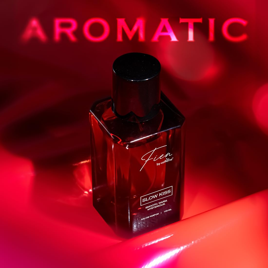 Perfume bottle labeled 'Fieu' with 'SLOW KISS' on a red background with 'AROMATIC' text.