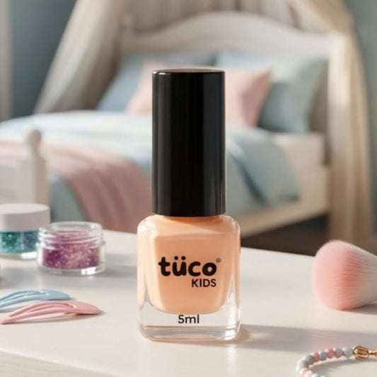 Bottle of tüco Kids nail polish on a table with decorative items in the background