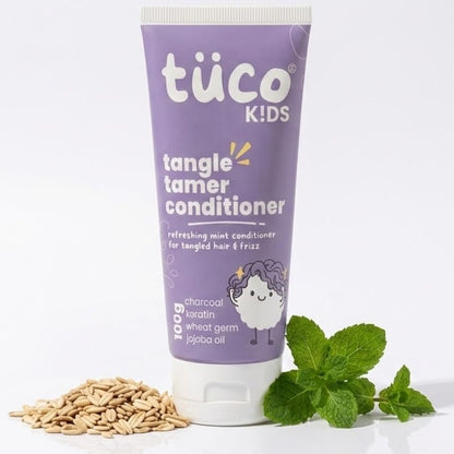 Tube of tüco Kids tangle timer conditioner with charcoal, wheat germ, and mint leaves on a white background