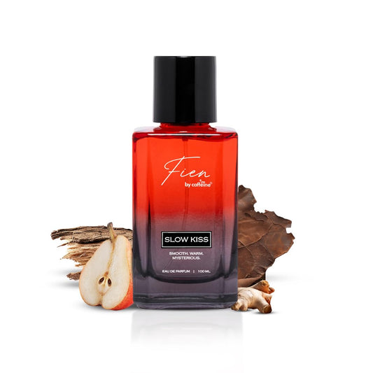 Perfume bottle labeled 'Fien' with a red and black design, surrounded by dried elements on a white background.