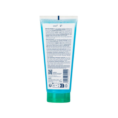 Back view of a blue and green tube with text and a QR code on a white background