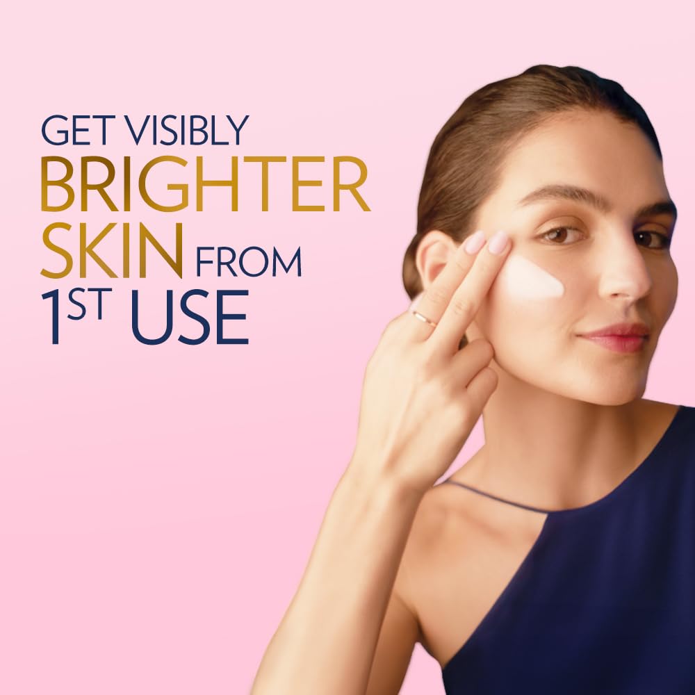 Woman applying cream to her face with text promoting visibly brighter skin from 1st use on a pink background