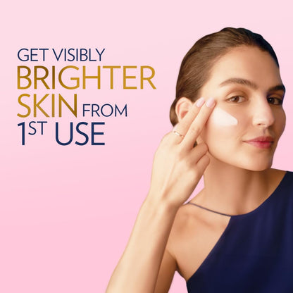 Woman applying cream to her face with text promoting visibly brighter skin from 1st use on a pink background
