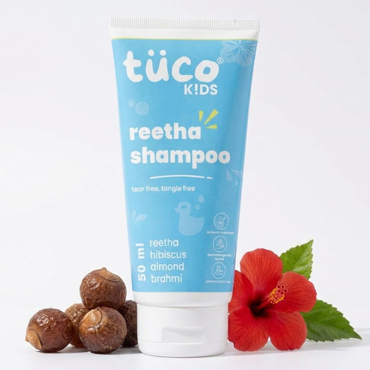 Töuco Kids reetha shampoo tube with a red flower and dried fruits on a white background