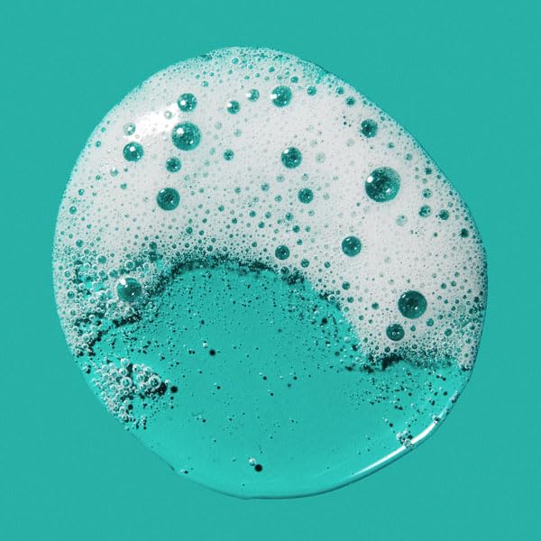Close-up of a turquoise liquid with bubbles on a teal background