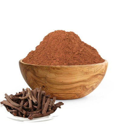 Wooden bowl filled with red powder and dried roots on a white background