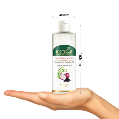 Biotique Onion Black Seed hair oil bottle held in a hand with measurements indicated.