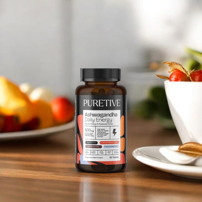 PURETIVE Ashwagandha Daily Energy supplement bottle on a wooden table with fruits and a bowl in the background.