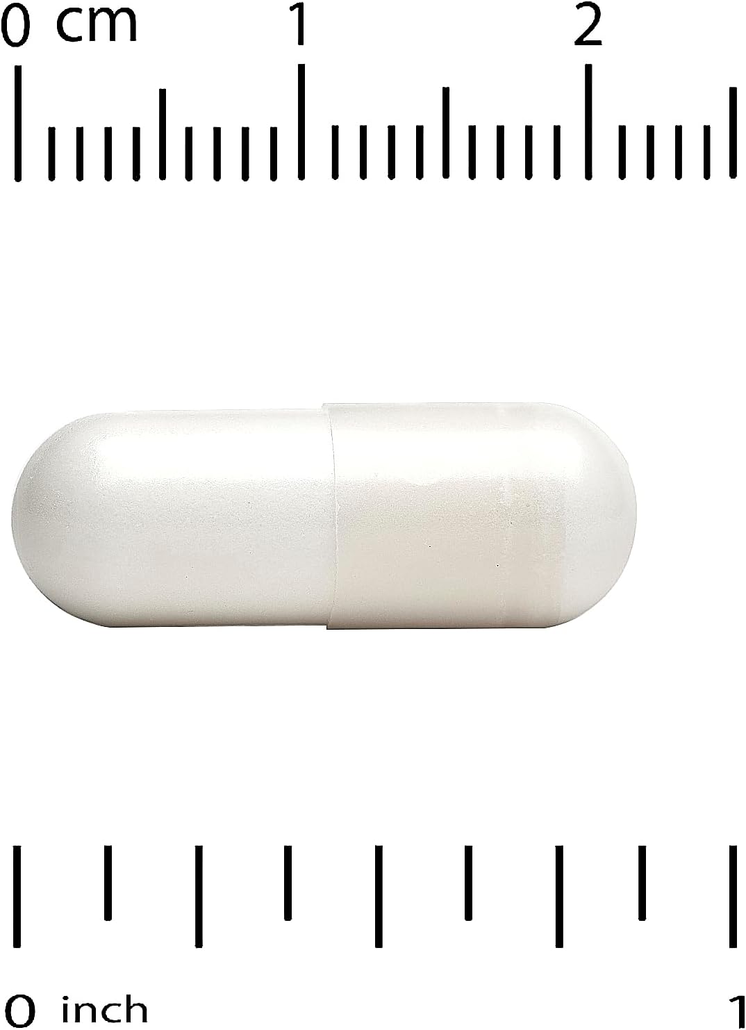 White capsule pill with a ruler for scale on a white background