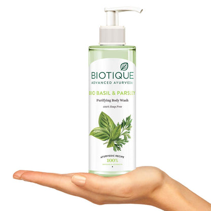 Biotique Basil & Parsley Purifying Body Wash bottle held in a hand on a white background