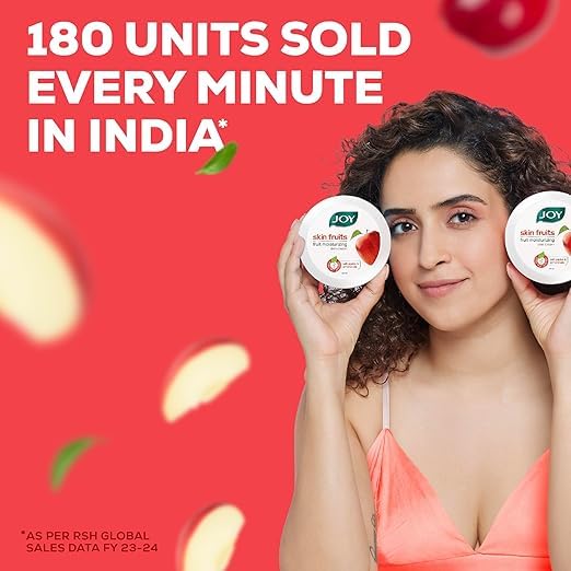 Woman holding two jars of Joy skin fruits product with a red background and text about sales figures.