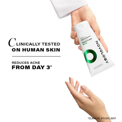 Hand holding a skincare product with text about clinical testing and acne reduction on a white background