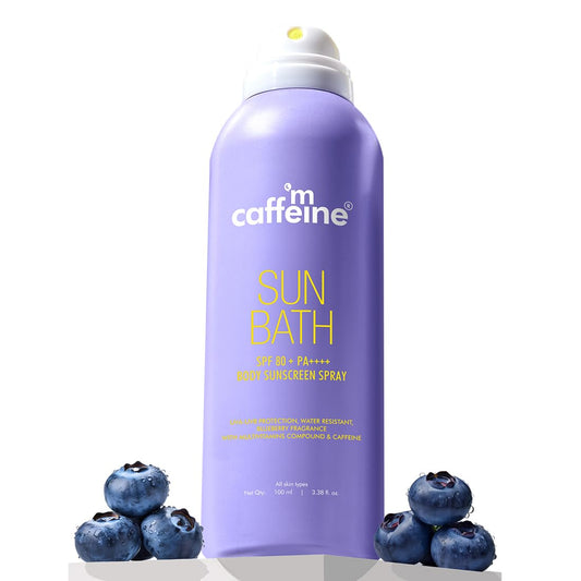 Purple sunscreen spray bottle with blueberries on a white background