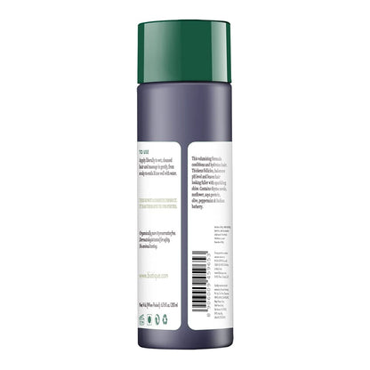 Back view of a cosmetic bottle with a green cap on a white background