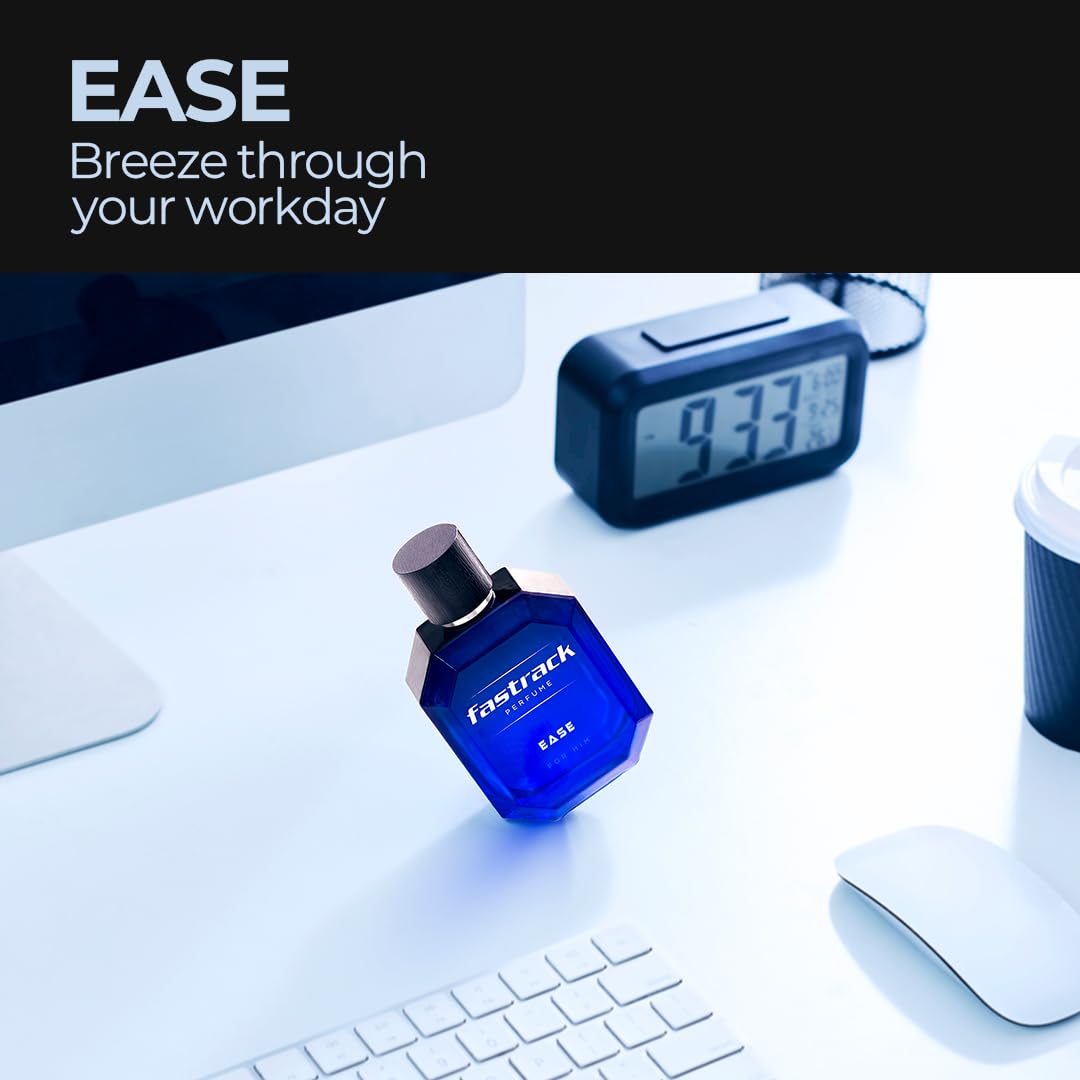 Blue Fastrack perfume bottle on a desk with digital clock and computer monitor.