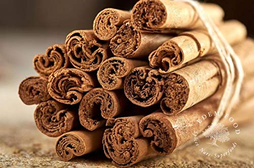Bundles of cinnamon sticks with a brand name on a wooden surface