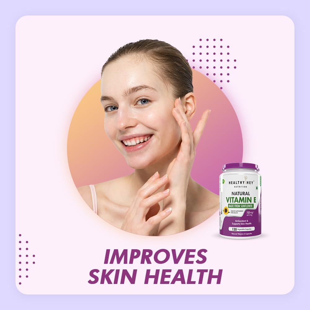 Woman touching her face with a bottle of Healthy Day Natural Vitamin E supplement on a light purple background.
