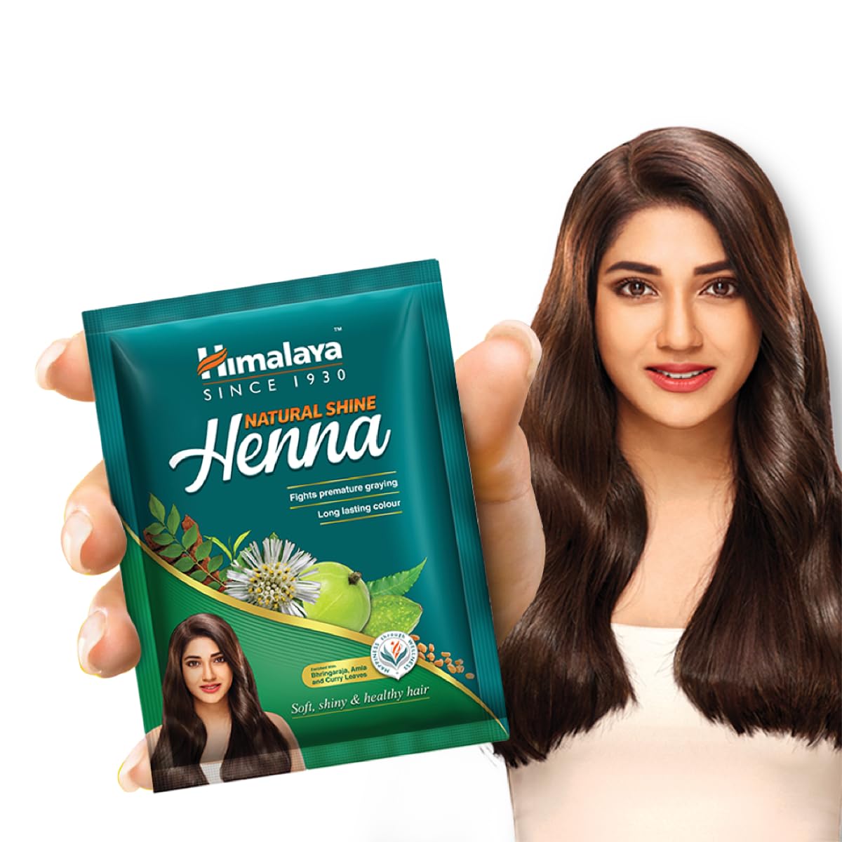 Himalaya Natural Shine Henna packet held by a person with long brown hair.