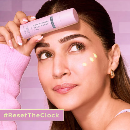 Woman holding a skincare product with a pink background