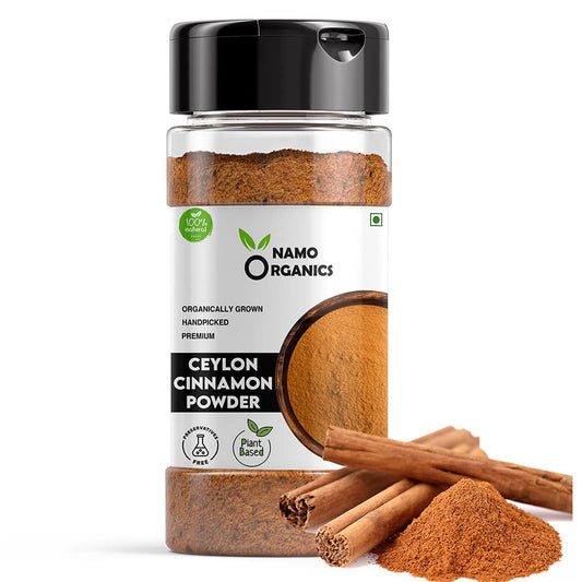 Jar of Namo Organics Ceylon Cinnamon Powder with cinnamon sticks and powder on a white background