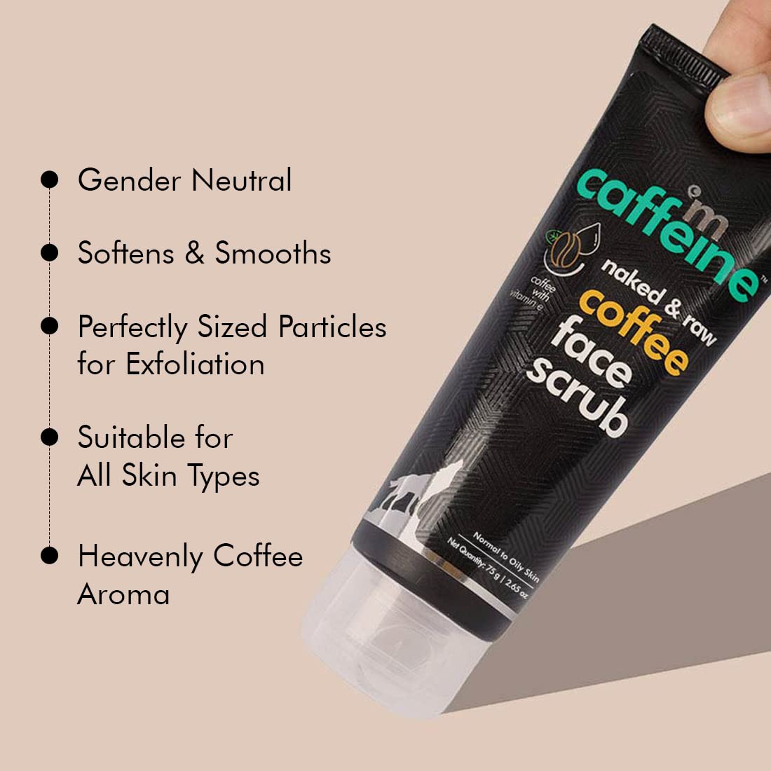 Caffeine Coffee Face Scrub tube held by a hand with product features listed on a beige background