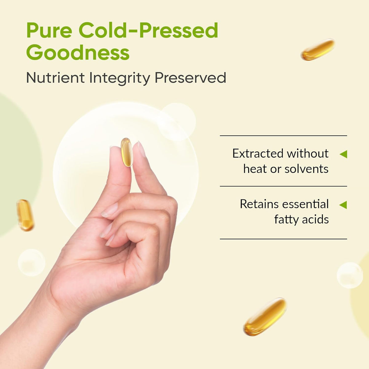 Hand holding a capsule with text about pure cold-pressed goodness and nutrient integrity on a light yellow background.
