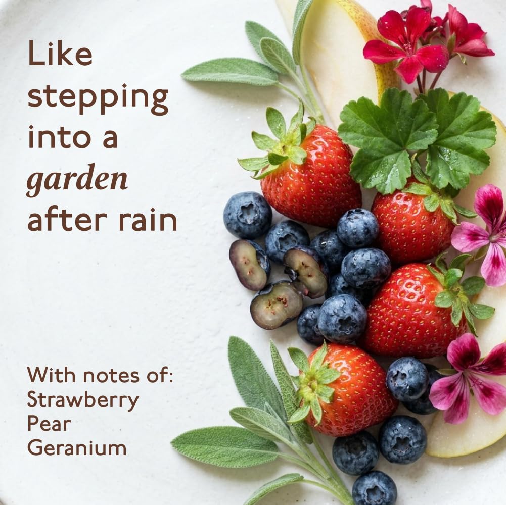Fruits and flowers arranged on a white surface with text describing a fragrance.