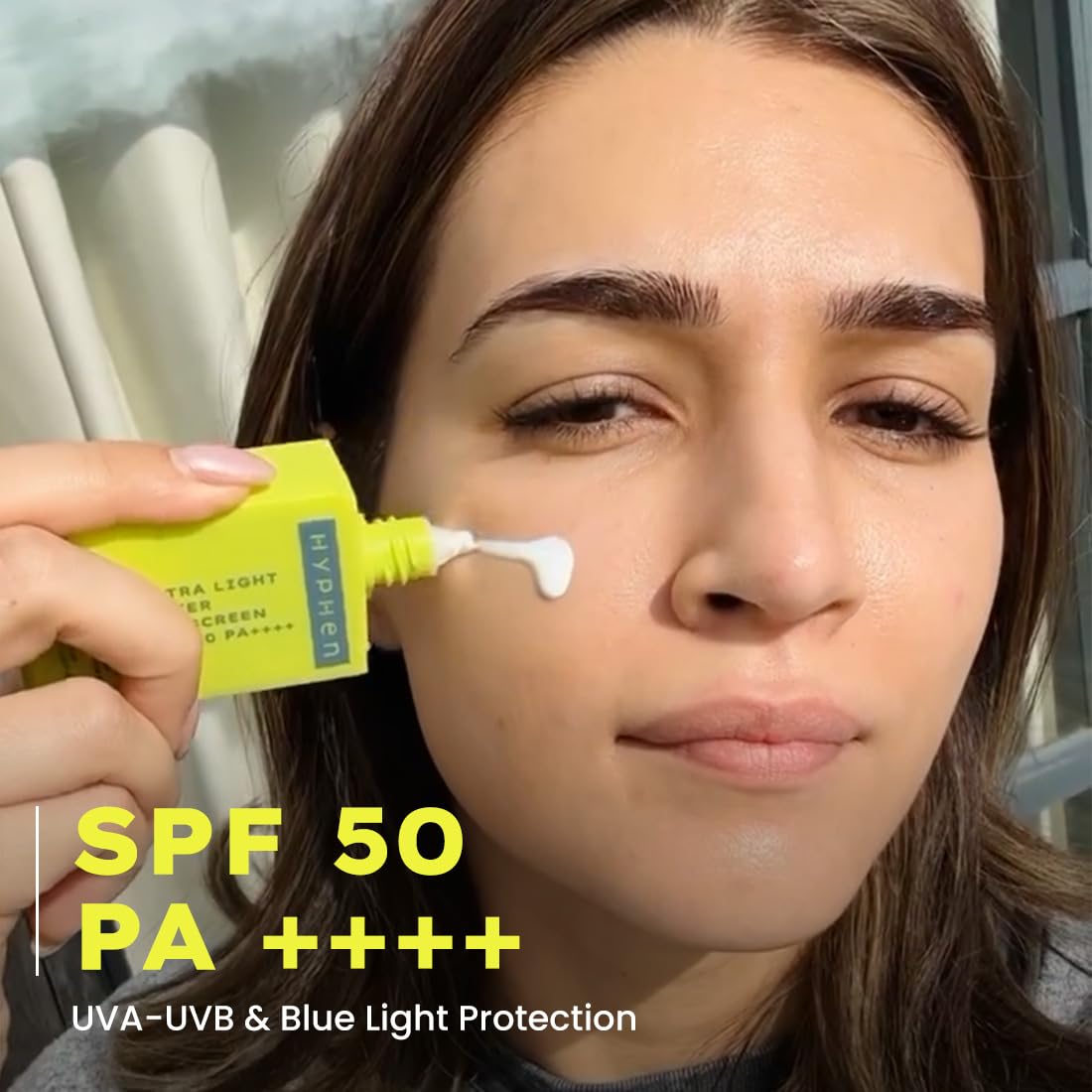 Person applying sunscreen to their face with a focus on SPF 50 PA++++ protection.