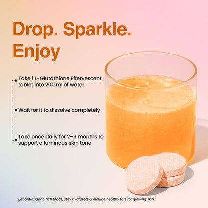 Glass of orange liquid with effervescent tablets on a pink background, featuring text about taking 1 L-Glutathione Effervescent tablet into 200 ml of water.