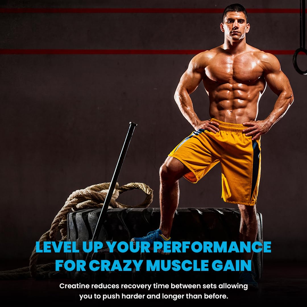Muscular man in yellow shorts standing next to a tire with fitness equipment, promoting muscle gain.