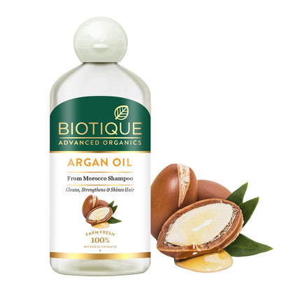 Biotique Argan Oil shampoo bottle with argan nuts and leaves on a white background