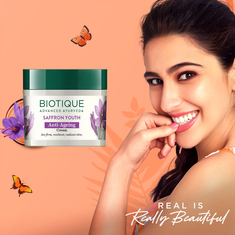 Biotique saffron youth anti-ageing cream with a smiling woman on an orange background
