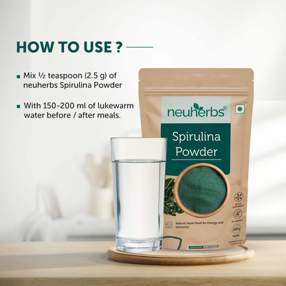Neuherbs Spirulina Powder packaging with a glass of water on a wooden surface.