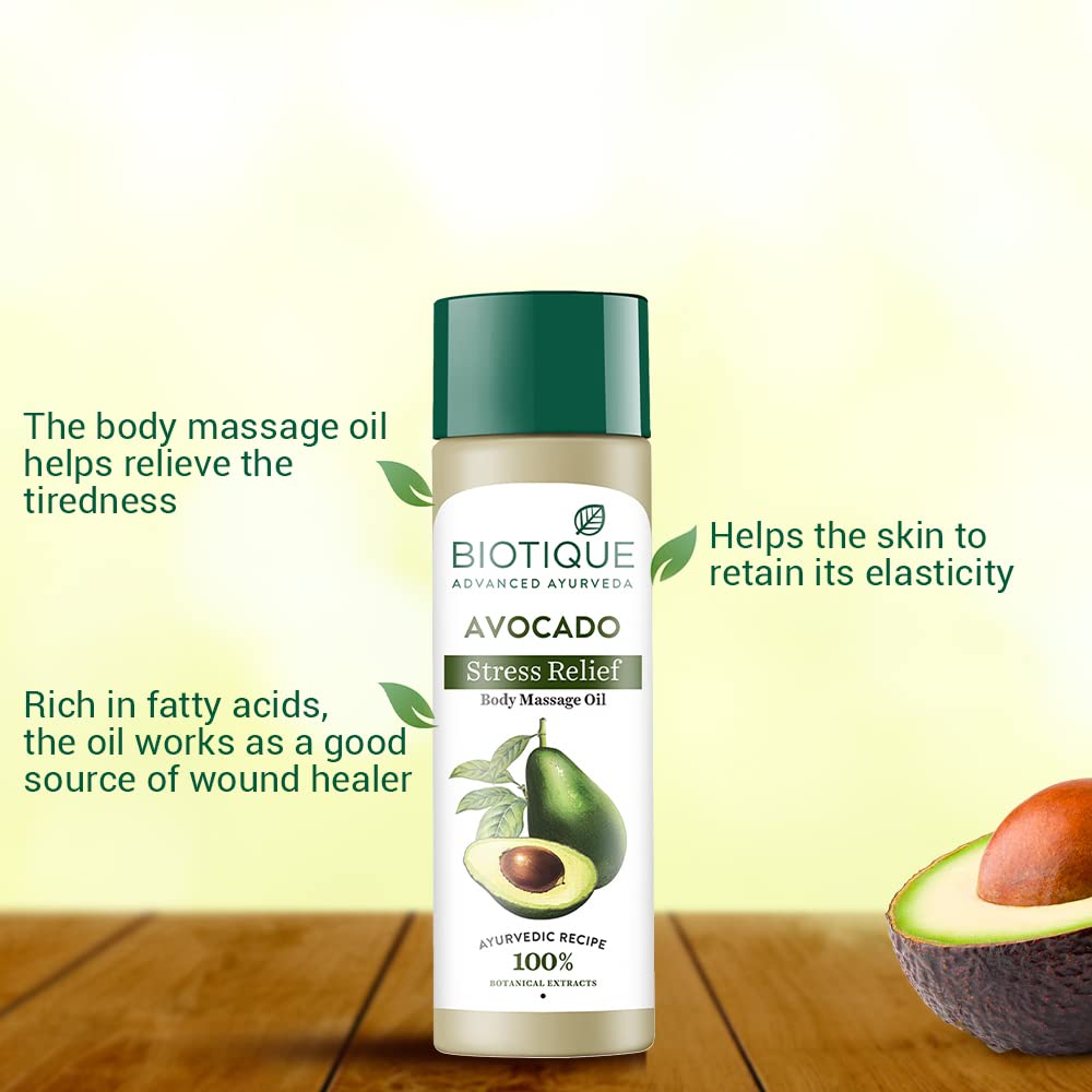Biotique Avocado Stress Relief body massage oil bottle with avocado on a wooden surface