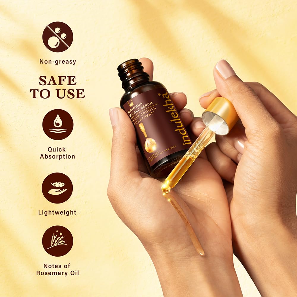 Indulekha hair oil bottle with dropper being used, on a beige background