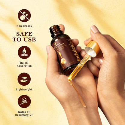 Indulekha hair oil bottle with dropper being used, on a beige background