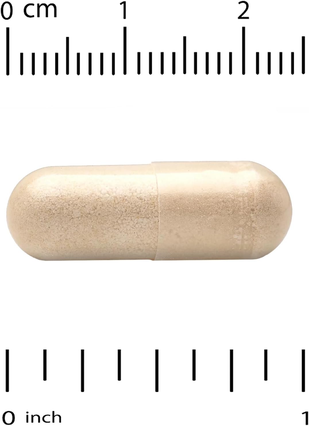 Beige capsule pill with a ruler for scale on a white background