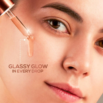 Close-up of a woman's face with a dropper applying a product, labeled 'Glassy Glow in Every Drop'.