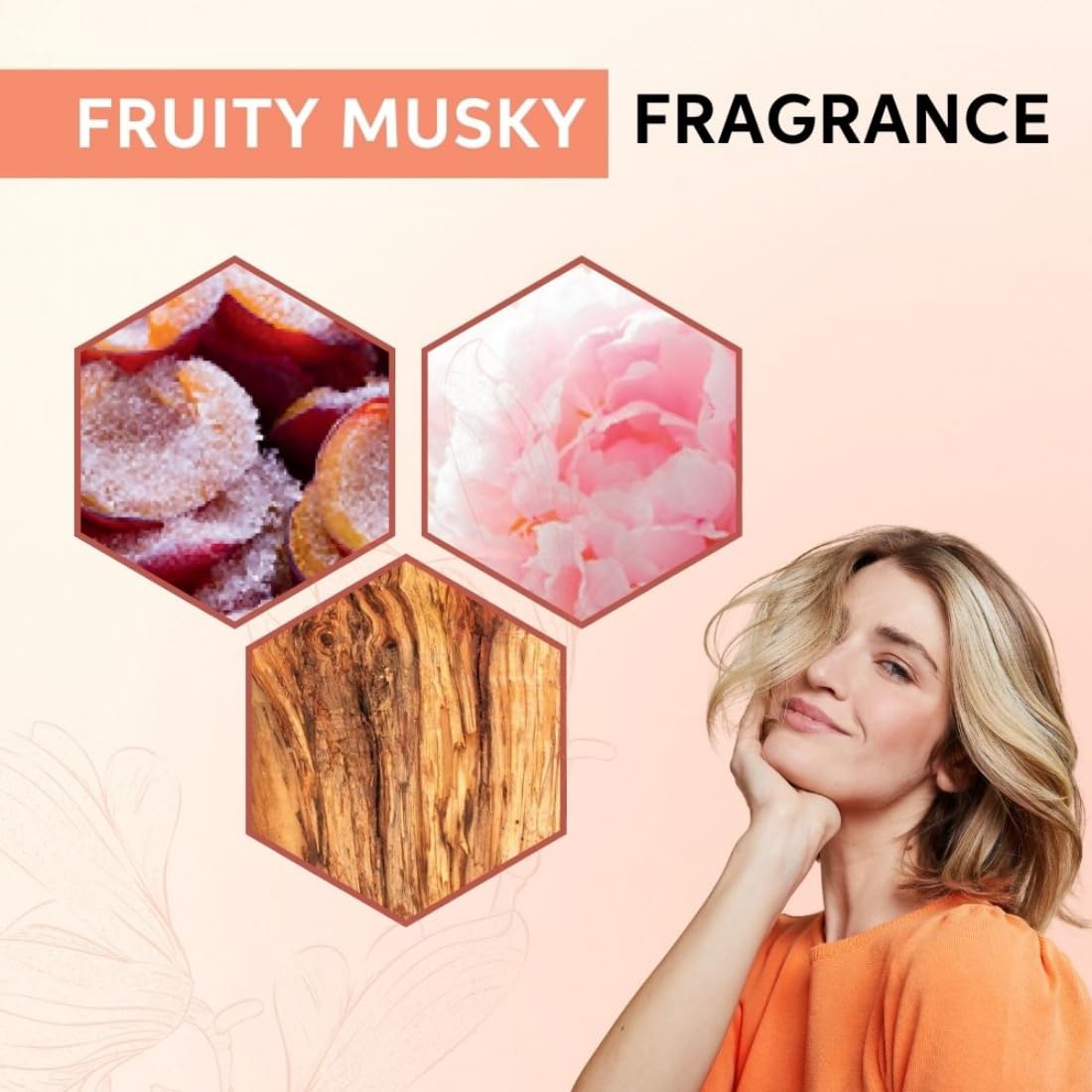 Advertisement for fruity musky fragrance with a woman and floral, wood, and fruit elements on a pink background.