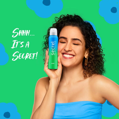 Woman holding a Secret deodorant can against a green background with blue flowers.