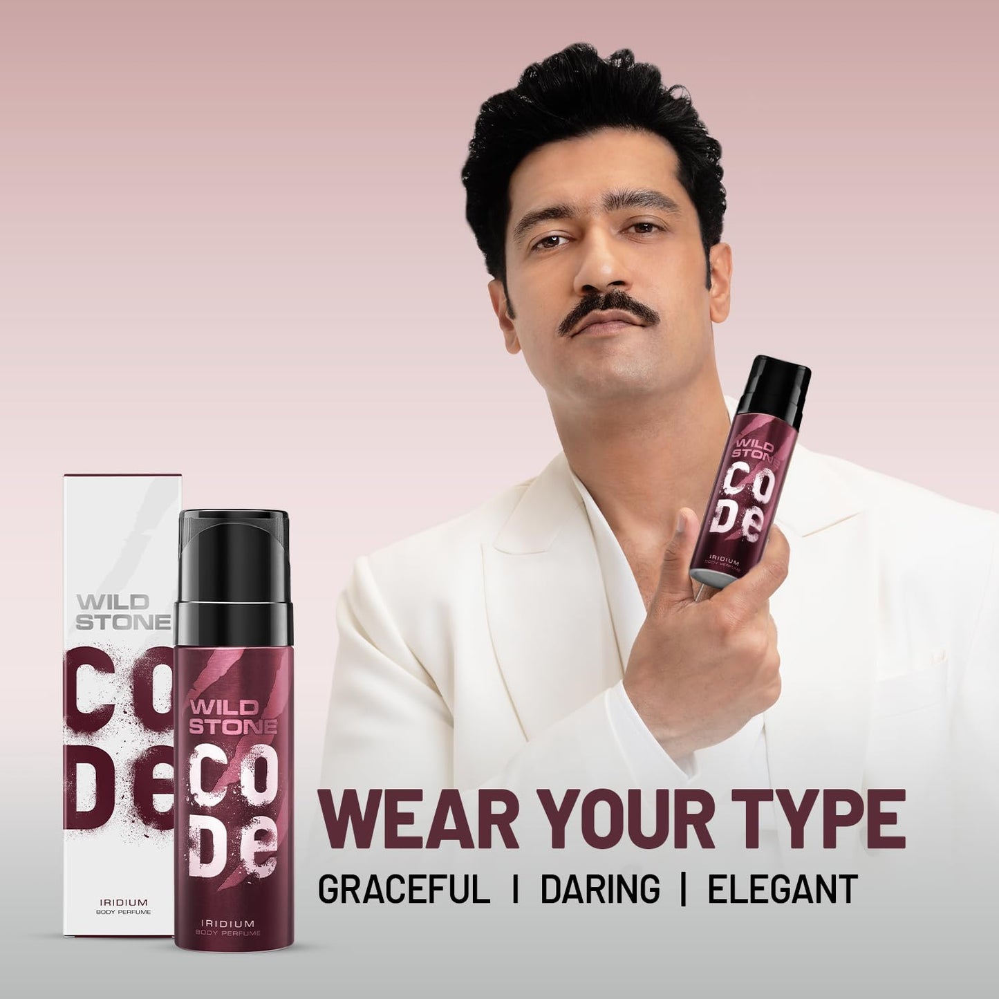 Man holding Wild Stone Code perfume with product packaging on a pink background