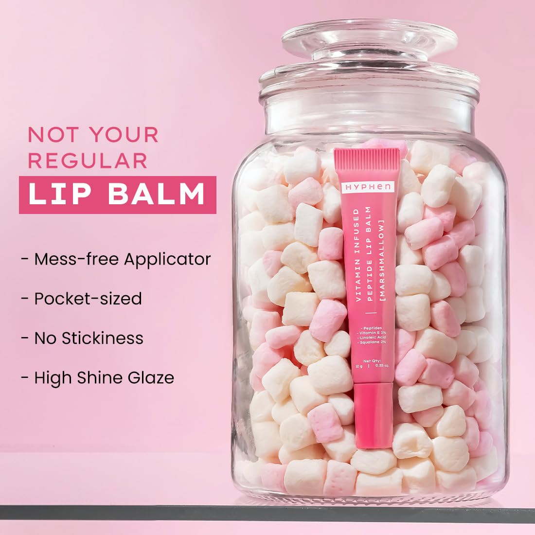 Pink lip balm in a jar filled with candy on a pink background